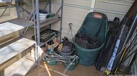 Metal shelving unit with multiple shelves, some rust spots, sized about 30x12x56.5in, with green tubs and baskets containing garden items below