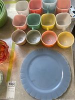 Overview of all pastel GlassBake cups and the blue Pyrex plate on table