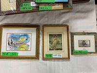 Three framed art pieces laid on a table showing sizes and styles