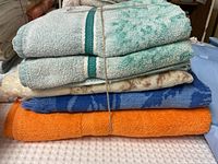 Stack of five assorted towels tied with string showing various colors and patterns