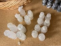 White marble chess pieces arranged on a cork surface with varying translucency and carved details.
