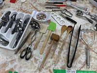 Full lot view showing assortment of cutlery and kitchen tools laid out on a table.