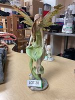 Front view of the 13.5-inch fairy figurine showing full figure, wings, and leaf base with flowers