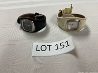 Two Fossil wrist watches placed next to each other on fabric surface, showing the overall look including straps and faces.