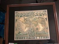 Full view of framed vintage Earth hemispheres map with two large hemispheres and smaller circular maps on top and bottom, wooden frame