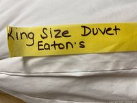 Photo of white king size duvet with a yellow label indicating 'King Size Duvet Eaton's'.