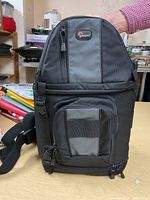 Front view of the Lowepro shoulder bag showing zippered pockets and Lowepro logo.