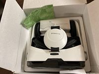 Top view of box showing Bobova VR headset, Bluetooth remote controller box, and green cleaning cloth.