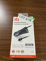 Front packaging of iQ Mobile Power Rapid In-Car Charger with 1.2m Lightning cable on wooden surface.