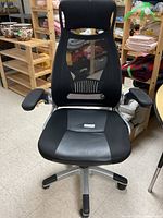 Front view of the black office chair showing mesh back and leather seat.
