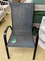 Front view of the outdoor chair showing the metal frame, armrests, and gray mesh fabric seat and backrest.