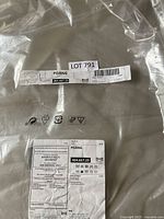 Photo of the IKEA POÄNG outdoor chair cushion in original sealed packaging, showing product labels with model number 404.667.23 and care instructions.