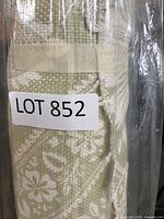 Front view of the fabric roll showing the beige and white floral pattern with a lot sticker.