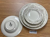 Stack of plates and soup bowl showing the detailed floral and vine pattern with gold trim.