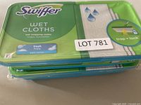 Top view of stacked two new sealed packages of Swiffer Wet Cloths fresh scent with trap and lock feature.