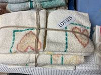 Bundle of towels and facecloths tied with string showing heart pattern design