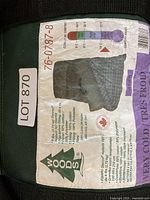 Thermal comfort rating tag on Woods sleeping bag showing temperature range and product codes.