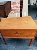 Front view of teak cabinet showing single drawer and recessed pull