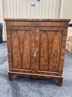 Front view of the cabinet with doors closed showcasing wood grain and panel design
