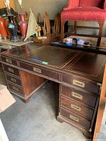 Front view showing entire desk with nine drawers and leather top