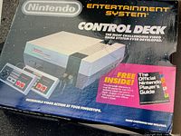 Front view of original NES Control Deck box showing artwork and included controllers graphic