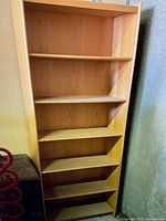 Full front view of the entire bookshelf showing six shelves and wood grain detail.
