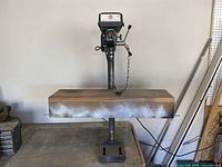 Front view of the King Canada 8" bench drill press standing on a wooden base, showing the full unit including the metal column and base.