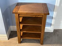 Front view showing table with three shelves and mission style design