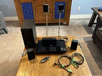 Full view of Blu-ray home theatre system components including player, subwoofer, satellite speakers, remote, and cables