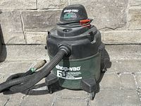 Shop-Vac wet/dry vacuum in upright position showing front side with hose attached and details on capacity label.