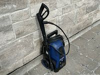 Full view of the Simoniz electric pressure washer showing the hose wrapped around the unit, spray gun, and wheels.