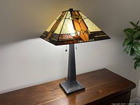 Lamp lit on wooden table showing full lamp and base