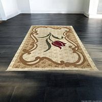 Full view of beige carpet on dark floor showing tulip motif and ornate border from above, well lit.