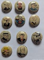 Top view showing all 11 buttons arranged in a grid, displaying various male cartoon characters including Superman and Dick Tracy, with cream backgrounds and colorful prints.
