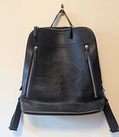Front view of Ben Minkoff black textured leather knapsack with two functional silver zipper accents.