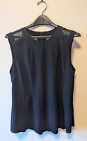 Front view of Nic and Zoe black sleeveless top on hanger against a plain background, showing solid black fabric with mesh panels on shoulders.