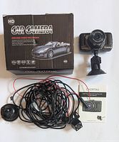Photo showing the dashcam with suction mount, long wiring set, box, and instruction manual