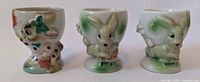 Front view of three ceramic bunny shaped egg cups showing details and paint
