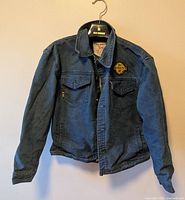 Front view of the denim jean jacket showing two chest flap pockets and a smaller Brooklyn patch on the left chest pocket.