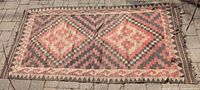 Full view of the rectangular woven rug laid flat, showing overall geometric diamond pattern and color tones.