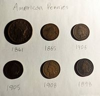 Photo of six American pennies with dates 1861, 1865, 1906, 1905, 1908, 1898 with handwritten labels