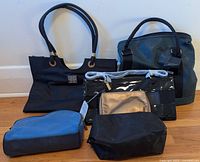 Six bags arranged on floor showing different styles and sizes