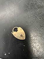 Front view of the 9ct gold heart pendant lock showing the keyhole and decorative screws.