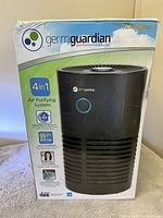 Photo of the front side of the GermGuardian AC4700BCA air purifier box showing product image and branding.