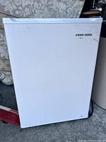 Front view of the white Black & Decker mini fridge showing door and logo.