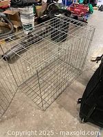 Metal wire dog cage with front open door, showing wire grid construction and floor grid.