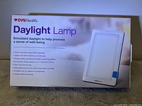 Front of the product box showing the CVS Health Daylight Lamp with features and image of the lamp.