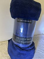 View of the blanket rolled up, showing the label with size and material details