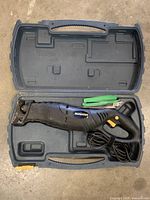 Mastercraft reciprocating saw inside open blue carrying case on a concrete floor
