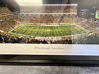 Close-up panoramic image of Pittsburgh Steelers stadium with crowd, field, and end zones visible with 'Pittsburgh Steelers' text below the photo.
